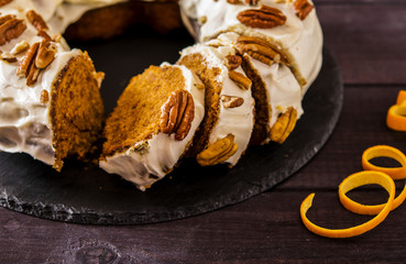 Spicy carrot and orange cake on a dark wooden background 