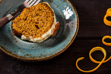 Spicy carrot and orange cake on a dark wooden background 