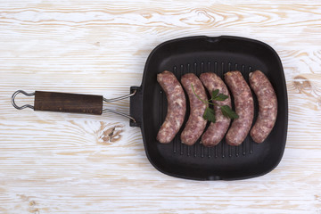 raw sausages on a  pan,  wooden background