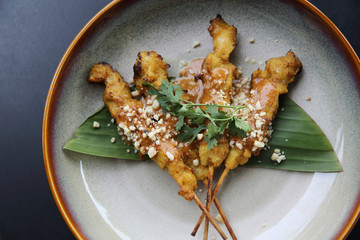 chicken satay, sate ayam and lontong with peanut sauce