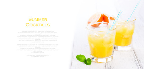 Summer yellow orange lemonade with ice and blood oranges and straw on a wooden table on a white background with place for text, copy space, horizontal, closeup