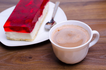 A cup of cappuccino coffee with slice of  cake