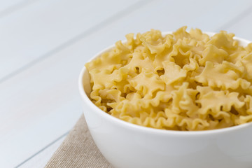 Raw campanelle pasta in a white bowl