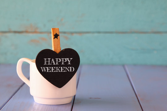 cup of coffee and little heart shape chalkboard with the phrase: HAPPY WEEKEND.