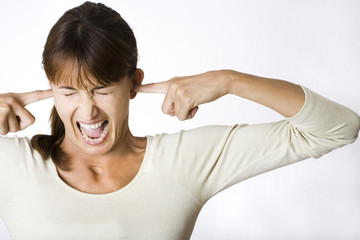 gros plan de visage de femme qui bouche son oreille