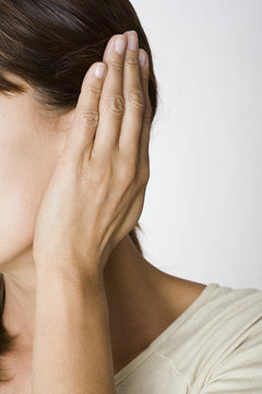gros plan de visage de femme qui bouche son oreille
