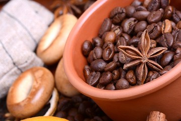 orange and lemon, coffee beans and cinnamon on wooden brown background.