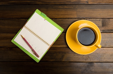 notebook, pen and cup of coffee in wood table