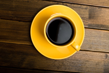 yellow cup coffee on wood background