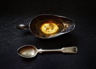 turmeric in a vintage spoon on a black background
