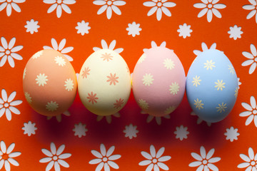 Easter eggs in pastel color on patterned background