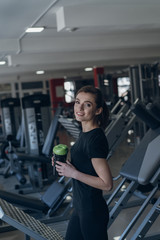 Fototapeta na wymiar Beautiful girl holding a shaker in the gym