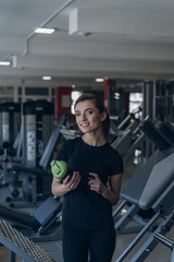 Fototapeta premium Beautiful girl holding a shaker in the gym