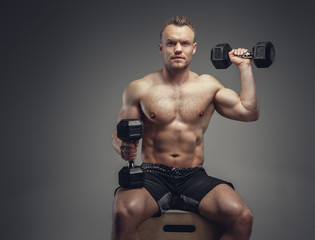 A man holds a pair of dumbbells.