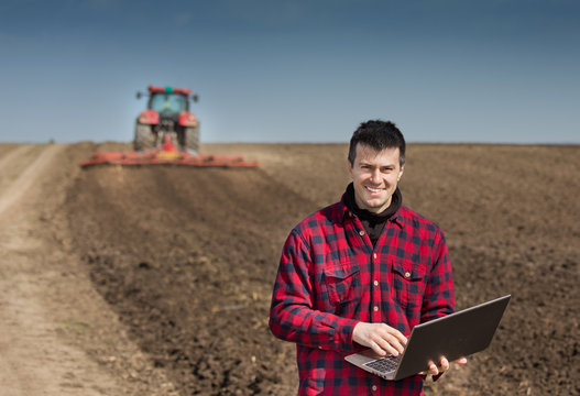 Farmer with laptop on the farmland