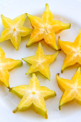Starfruit slices on a white plate.