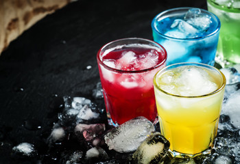 Set of cocktails with ice, black background, selective focus