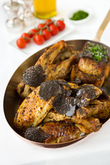 Roasted chicken with foie gras and truffle sauce, topped with sliced truffle, served in a metal pan. © dannyburn