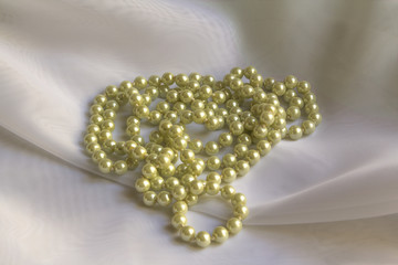 Pearl necklace on a White silk