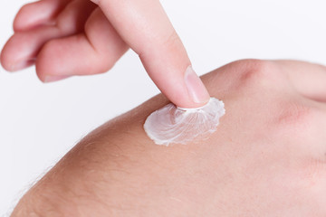 Fototapeta premium Mann cremt sich die Hand mit Schutzcreme ein