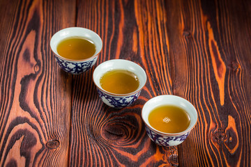 Cups with green tea on wooden background
