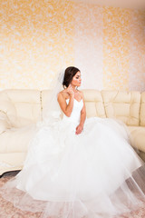 Fototapeta na wymiar Beautiful bride in the interior sitting on couch