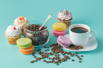 cup of coffee with colorful macaroons and coffee beans