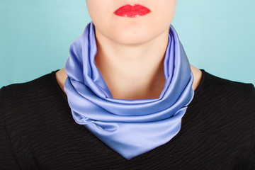 Silk scarf. Blue silk scarf around her neck isolated on blue background.