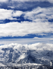 Fototapeta na wymiar Sunlight snowy mountains in clouds