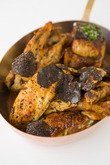 Roasted chicken with foie gras and truffle sauce, topped with sliced truffle, served in a metal pan. © dannyburn