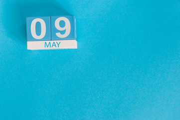 May 9th. Image of may 9 wooden color calendar on blue background.  Spring day, empty space for...