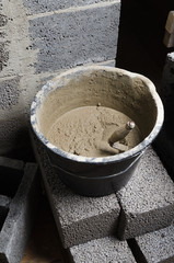 A bucket with a solution and a trowel, close-up