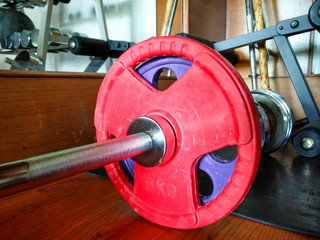 barbells with red weights on gym floor