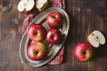 Red apples on plank wooden table, horizontal.