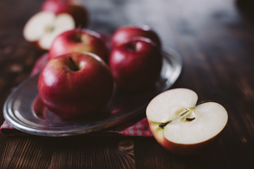 Red apples on plank wooden table