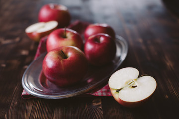Red apples on plank wooden table