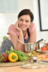 Portrait of beautiful woman cooking in home kitchen