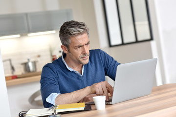 Fototapeta premium Man working from home-office with laptop computer