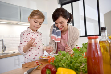 Mom and daughter cooking together in modern kitchen