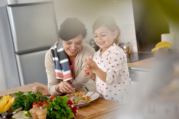 Mom and daughter cooking together in modern kitchen