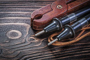 Antique electric tester pliers on vintage wooden board electrici