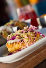 Mexican fried cod fish taco served with lettuce, red onion and sauce