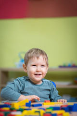 Boy playing with toys in nursery © poplasen