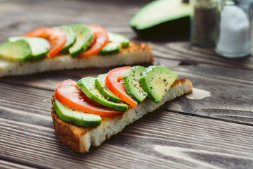 Fresh tomato and avocado slices with toasts. Selective focus shooting angle 30 degrees.