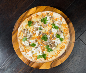 Gourmet goats cheese, mozzarella and truffle pizza served on a rustic wooden board