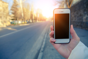 a girl gets on the a telephone hip, takes pictures a street