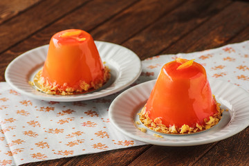 Mini orande mousse cakes covered with glaze. Modern european cak