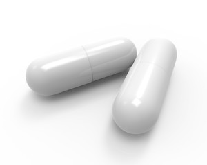 Close up of two white capsules isolated on white background.