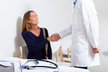 médecin qui sert la main à une patiente