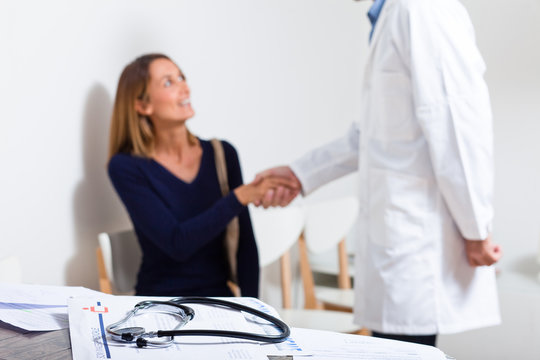 médecin qui sert la main à une patiente